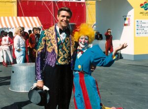 Sue Doctoroff Landay dressed as circus clown, standing with Ringling Ring Master