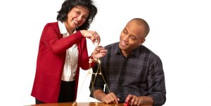 Two adults assembling a spaghetti tower for the Marshmallow Challenge