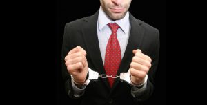 business man wearing hand cuffs / wrist shackles
