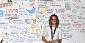 woman standing in front of a doodle-filled whiteboard