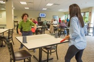 colleagues playing ping pong in a business lunchroom