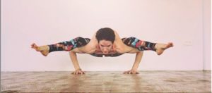 woman holding yoga pose, balancing on her elbows with straight legs